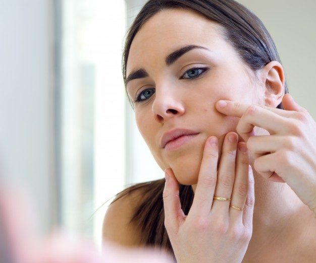 woman popping pimple
